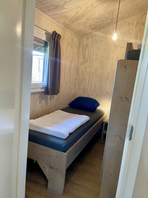 Petite chambre avec un lit simple dans une tente Safari lodge au camping de Noetselerberg aux Pays-Bas.
