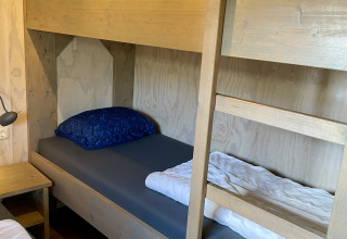 Lits superposés en bois dans une tente safari lodge au camping de Noetselerberg aux Pays-Bas, avec literie.
