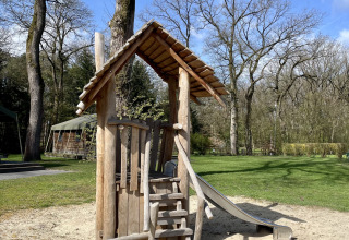 Aire de jeux en bois avec toboggan à la Safari Lodge, camping de Noetselerberg, Pays-Bas sous le soleil.