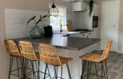 Cucina moderna in chalet al campeggio Mareveld, Paesi Bassi, con isola, sgabelli e luce naturale.