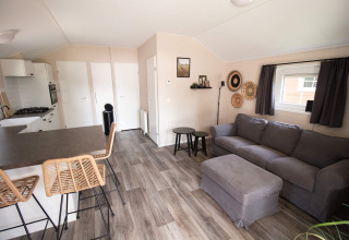 Modern luxury lodge interior with kitchen and living area at Campsite Mareveld in the Netherlands.