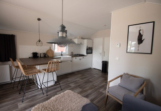 Cucina moderna e area soggiorno nel Luxe Chalet al campeggio Mareveld nei Paesi Bassi.