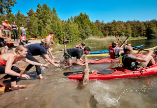 Mensen beleven een leuke kajakwedstrijd bij Nordskoven Strand Camping in Denemarken.