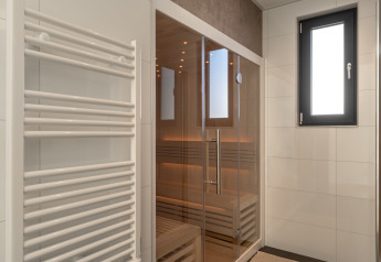 Moderne Sauna mit Glastür, Handtuchwärmer und Fenster in der Villa Bloomingdale, Bloemendaal, Niederlande.