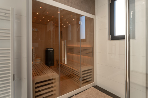 Moderne sauna met glazen deuren en houten banken in Villa Bloomingdale, MarinaPark Residentie Bloemendaal, Nederland.