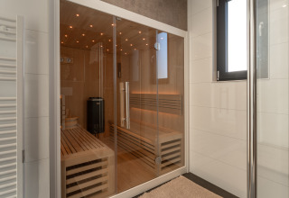 Moderne sauna met glazen deuren en houten banken in Villa Bloomingdale, MarinaPark Residentie Bloemendaal, Nederland.