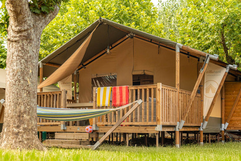 Safari telt Villatent Outback med træterrasse, hængekøje og farverige håndklæder udenfor.