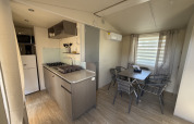Køkken og spisestue i en hytte på Campsite Seasonova Ensoya i Frankrig med moderne faciliteter.
