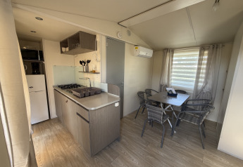 Kitchen and dining area in a cottage at Campsite Seasonova Ensoya in France, featuring modern amenities.