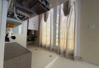 Modern cabin interior with sheer curtains, gas stove, and kitchen appliances at Cottage at Campsite Seasonova Ensoya, France.