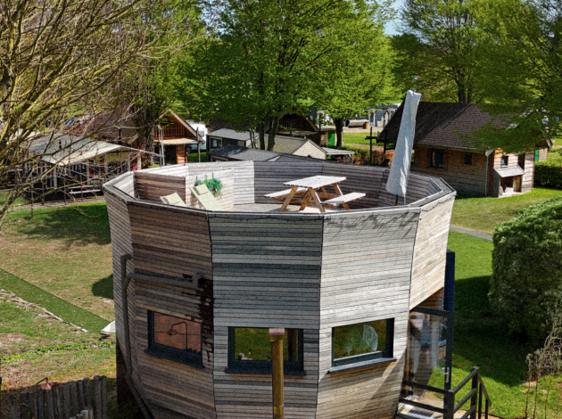 Unieke ronde Wellnest-lodge bij Camping Vinkenhof in Nederland, met houten terras en buitenspa.