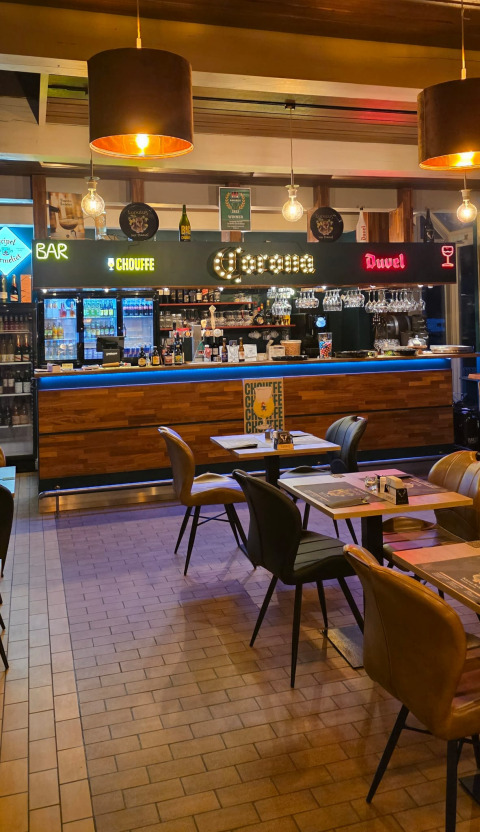 Binnenbar en eetgedeelte bij een glampingaccommodatie met moderne inrichting en verlichte bar.