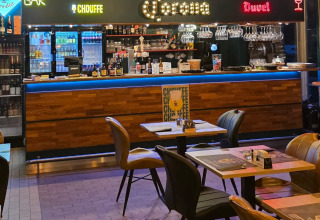 Binnenbar en eetgedeelte bij een glampingaccommodatie met moderne inrichting en verlichte bar.