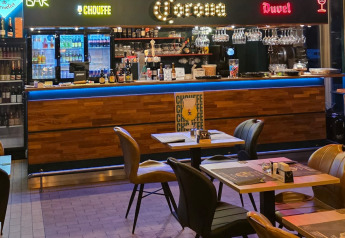 Bar et espace repas intérieur d’un hébergement glamping avec meubles modernes et comptoir éclairé.