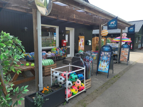 Fachada de la tienda de Skovly Camping con balones y juguetes en la Región de Selandia, Dinamarca.