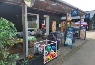 Fachada de la tienda de Skovly Camping con balones y juguetes en la Región de Selandia, Dinamarca.