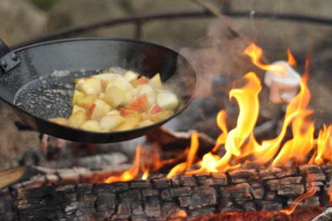 Padella con pezzi di mela che cuociono sul fuoco a Skovly Camping, Regione della Selandia, Danimarca.