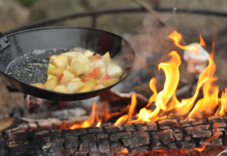 Poêle avec des morceaux de pomme cuisant sur feu de bois au Skovly Camping, Région Sjælland, Danemark.