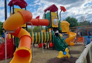 Aire de jeux colorée avec toboggans et tunnel au Camping Paradis Family des Issoux, Auvergne-Rhône-Alpes.