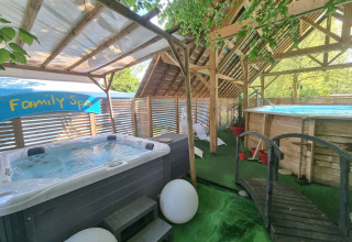 Espace spa familial avec jacuzzi, piscine et verdure au Camping Paradis Family des Issoux, en Auvergne-Rhône-Alpes.