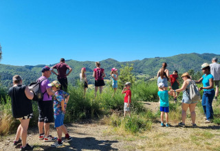 Familias y niños admiran el paisaje natural y colinas en Camping Paradis Family des Issoux, Auvernia-Ródano-Alpes, Francia.
