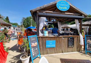 Buitenbar op Camping Paradis Family des Issoux met bezoekers die genieten van het zomerse vakantiegevoel.