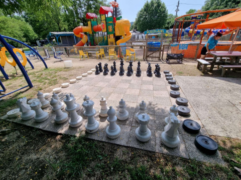 Ajedrez gigante al aire libre y zona de juegos en Camping Paradis Family des Issoux, Auvernia-Ródano-Alpes, Francia.
