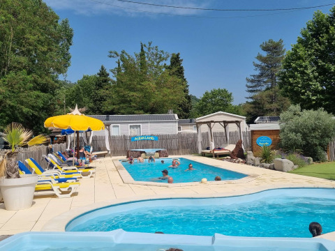 Piscines extérieures et vacanciers se détendant au Camping Paradis Family des Issoux en Auvergne-Rhône-Alpes, France.