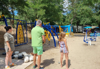 Familie spiller petanque og nyder legepladsen på Camping Paradis Family des Issoux i Frankrig.