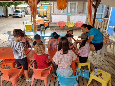 Kinderen knutselen samen aan een tafel op Camping Paradis Family des Issoux in Auvergne-Rhône-Alpes, Frankrijk.