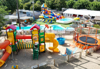 Spielplatz und Wasserrutschen im Camping Paradis Family des Issoux, Auvergne-Rhône-Alpes, Frankreich, farbenfrohe Anlage.