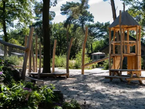 Wooden playground structure in Holiday park Latour, North Brabant, Netherlands, surrounded by trees.