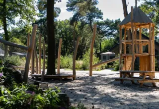 Area giochi in legno al parco vacanze Latour a North Brabant, Paesi Bassi, circondata da alberi.
