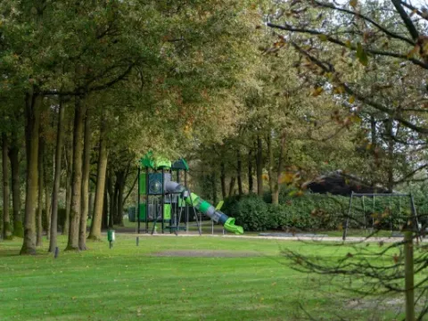 Playground surrounded by trees at Holiday Park Latour, a holiday resort in North-Brabant, Netherlands.