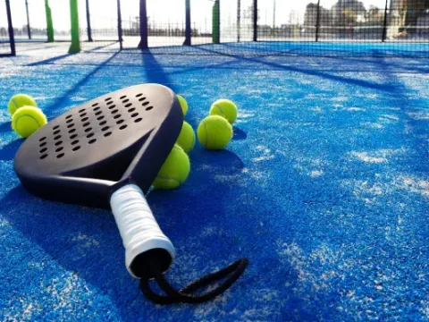 Pala y pelotas de pádel sobre pista azul del parque vacacional Latour, Brabante Septentrional, Países Bajos.