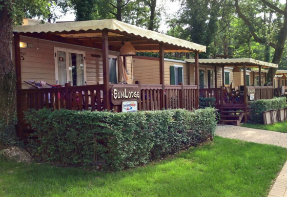 Foto de SunLodge Aspen, casas de madera con porche cubierto situadas en un entorno natural verde.