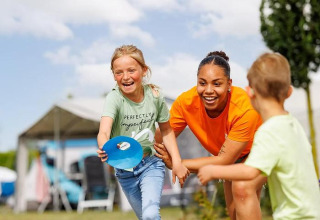 Due bambini e un'adulta giocano all'aperto al parco vacanze Arden Parks Tulderheyde ad Anversa, in Belgio.