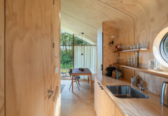 Interior of Wikkelhouse met Ligbad at Resort de Parel in the Netherlands with wood walls and window.
