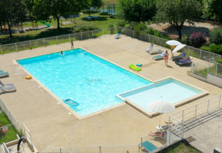 Piscina exterior con piscina infantil y tumbonas en Onlycamp Camping Les Tuillères, Auvernia-Ródano-Alpes.
