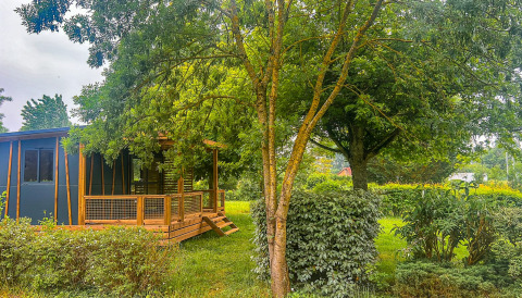 Houten huisje omringd door groen bij Onlycamp Camping le Champ d’Eté in Auvergne-Rhône-Alpes, Frankrijk.