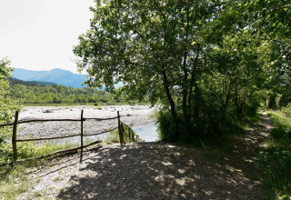 Pad en rivier bij Onlycamp Camping Les Tuillères, een vakantiepark in Auvergne-Rhône-Alpes, Frankrijk.