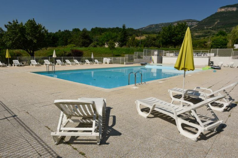 Udendørs swimmingpool med liggestole og parasoller på Onlycamp Camping Les Tuillères i Frankrig.
