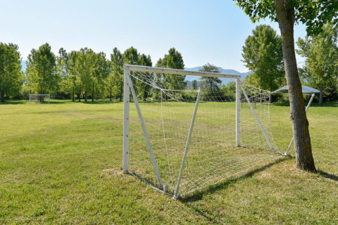 Campo de fútbol en Onlycamp Camping Les Tuillères en Auvergne-Rhône-Alpes, Francia, con árboles y porterías.