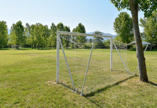 Fodboldbane ved Onlycamp Camping Les Tuillères i Auvergne-Rhône-Alpes med mål og grønne træer.