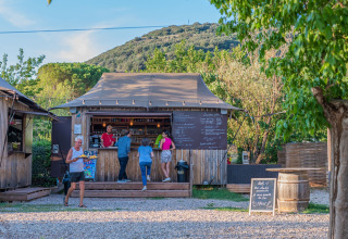 En udendørs café i Onlycamp Camping Les Vailhès, Occitanie, Frankrig, med folk der nyder sommeren.