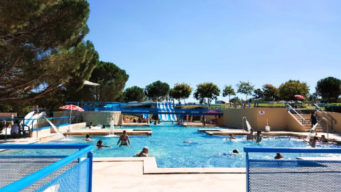 Buitenzwembad met waterglijbanen en gasten bij Onlycamp Camping de l'Argenté, Occitanië, Frankrijk.
