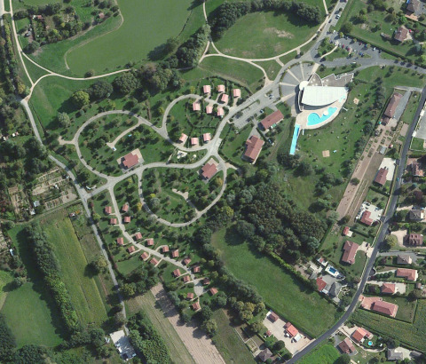 Luchtfoto van Onlycamp Camping le Champ d'Été met huisjes, groene zones en zwembad in Frankrijk.