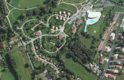 Vista aerea di Onlycamp Camping le Champ d'Été con bungalow, aree verdi e piscina in Francia.
