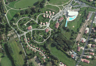 Luchtfoto van Onlycamp Camping le Champ d'Été met huisjes, groene zones en zwembad in Frankrijk.