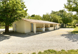 Buitenkeuken en sanitair gebouw bij Onlycamp Camping Les Tuillères in Auvergne-Rhône-Alpes, Frankrijk.